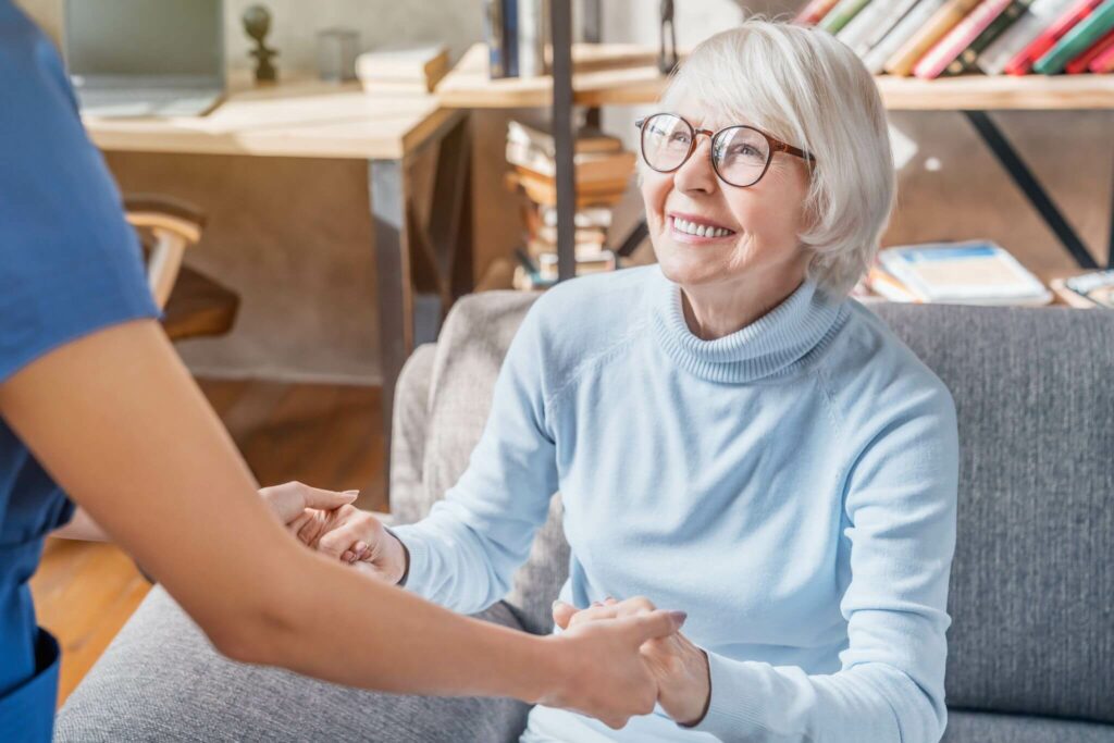 A woman smiling and being assisted by a nurse