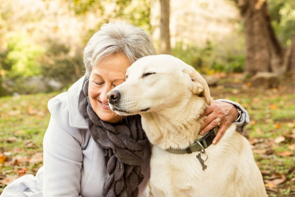 A woman in a warm embrace with her dog