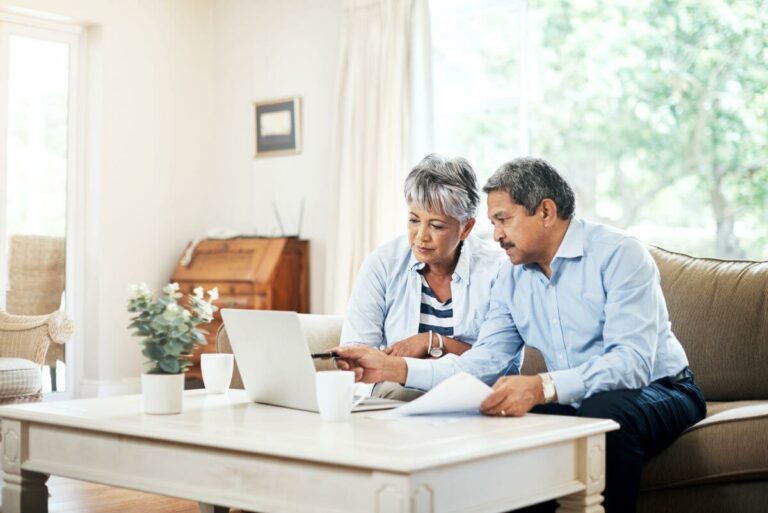 A couple looking at a laptop together in thier living room