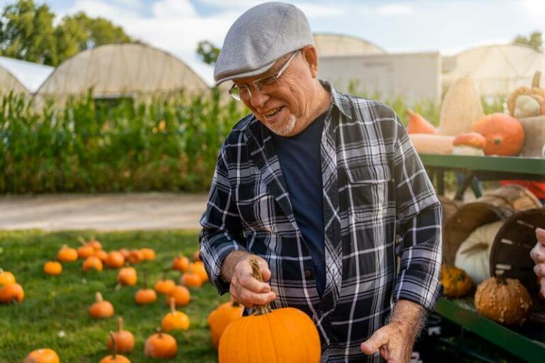 pumpkin patch - Bartlett Reserve - Senior Living Durham, NC Senior man picking out a pumpkin at a pumkin patch